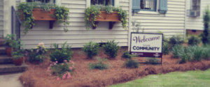 "Welcome to our Community" sign in a flower garden.