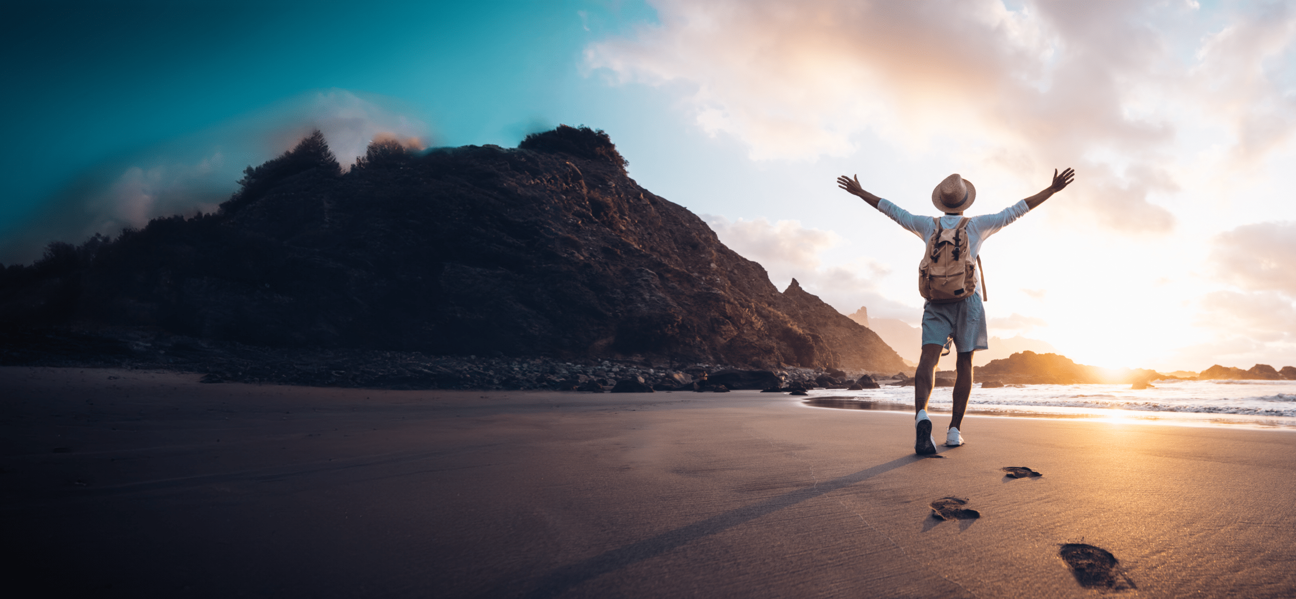 Man walking at the beach with both hands raised