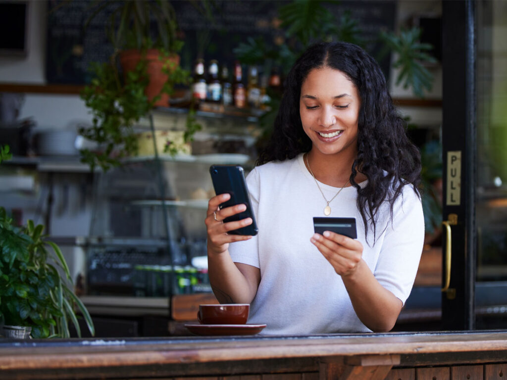 a woman holding a credit card and a phone