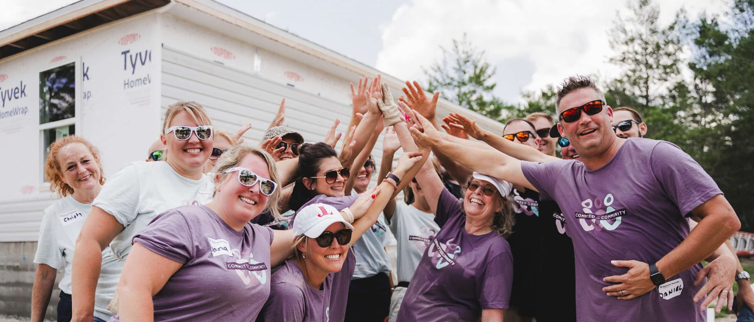 Community Bank team gathered in a team high-five.