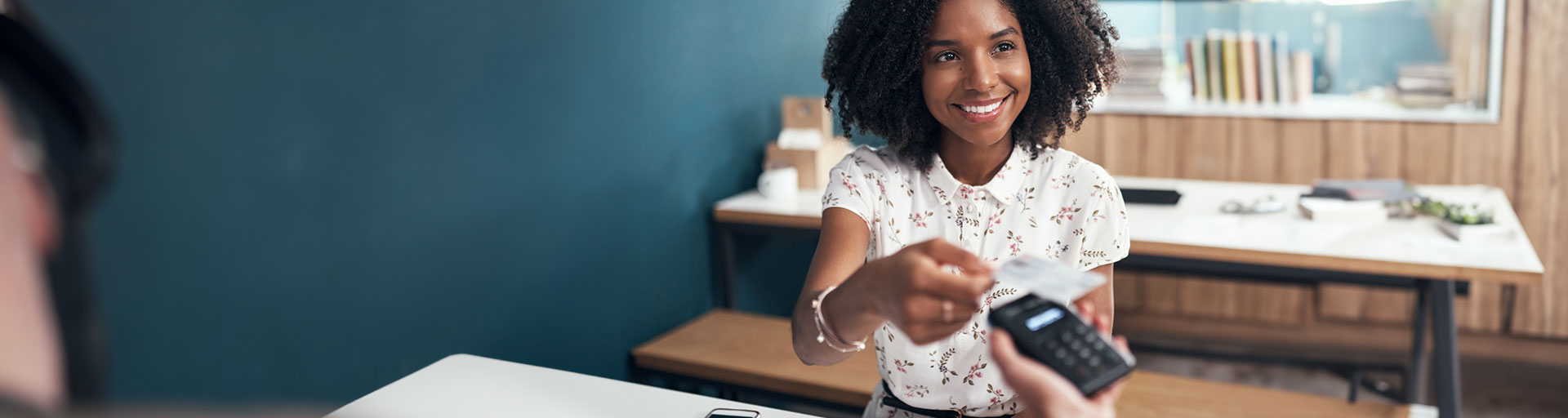 a person sitting at a table paying by credit card